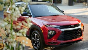 Red 2023 Chevrolet Trailblazer driving down a street near Anderson, Indiana