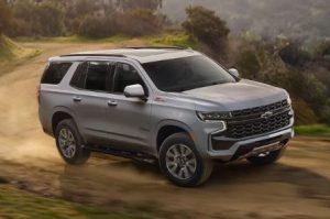 front side view of a silver 2023 Chevy Tahoe drving on a dirt road near Anderson, Indiana