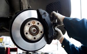 A person repairing a Chevy's brakes near Anderson, Indianapolis