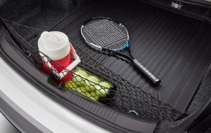 A photo of a tennis racket and tennis balls, with a water jug laid in the trunk of a 2024 Chevy Malibu near Anderson, Indiana