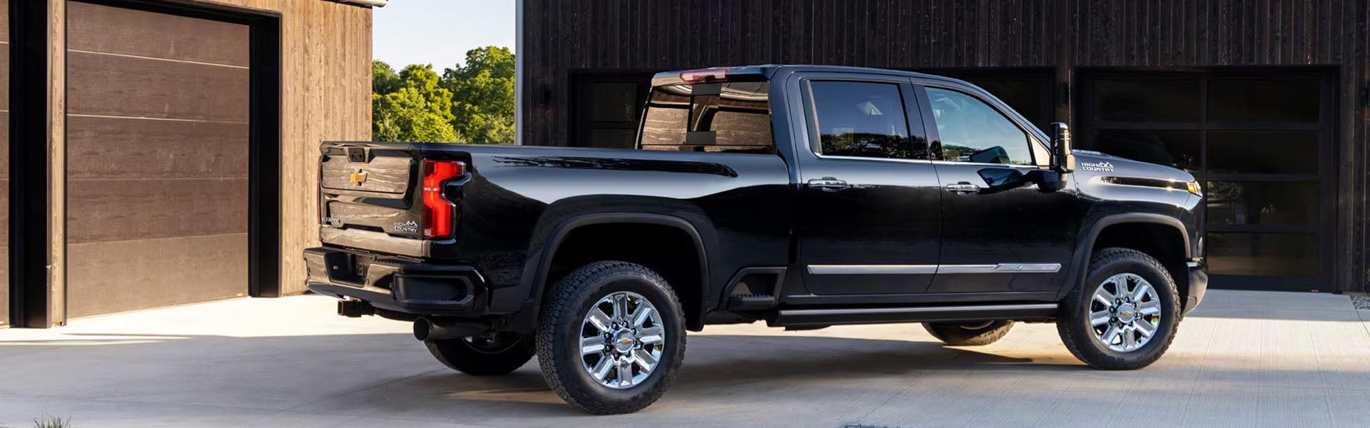 Black Chevrolet pickup truck parked outside a modern building with rugged styling and chrome wheels.