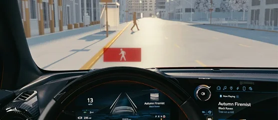 View from a Chevrolet driver's seat as a pedestrian alert appears on the windshield for a person crossing ahead
