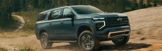A dark grey Chevrolet Suburban Z71 driving on a dirt road